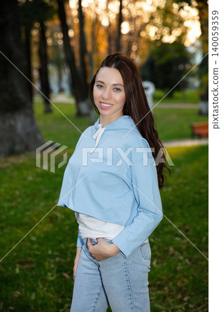 Smile woman dressed in a sweatshirt and jeans Smile woman dressed in a sweatshirt and jeans 140059359