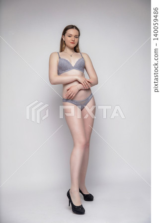 Young woman dressed in grey lingerie Young woman dressed in grey lingerie 140059486