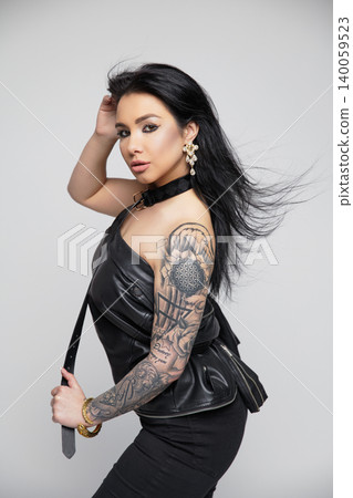Charming brunette dressed in a leather jacket and pants 140059523