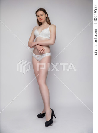Young lovely woman dressed in white lingerie Young lovely woman dressed in white lingerie 140059552