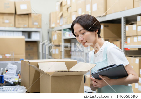 Middle-aged female worker in a warehouse Middle-aged female worker in a warehouse 140059590