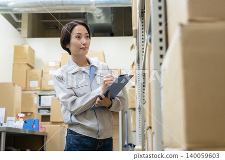 Middle-aged female worker in a warehouse Middle-aged female worker in a warehouse 140059603