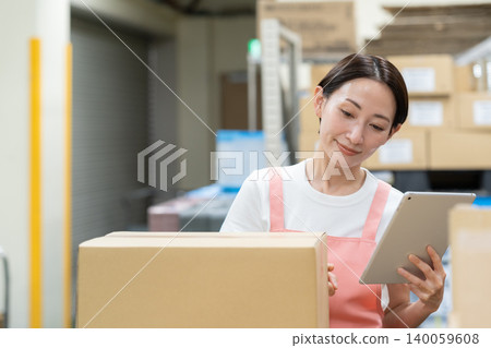 Middle-aged female worker in a warehouse 140059608