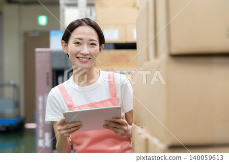 Middle-aged female worker in a warehouse Middle-aged female worker in a warehouse 140059613