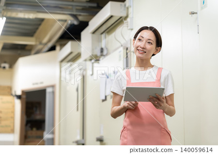 Middle-aged female worker in a warehouse Middle-aged female worker in a warehouse 140059614