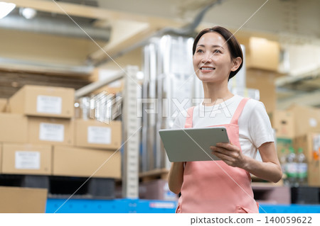 Middle-aged female worker in a warehouse Middle-aged female worker in a warehouse 140059622