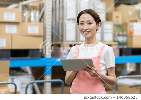 Middle-aged female worker in a warehouse Middle-aged female worker in a warehouse 140059623