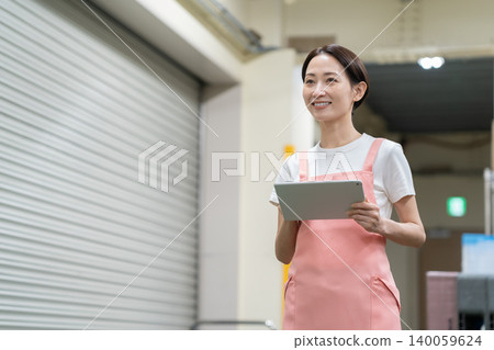 Middle-aged female worker in a warehouse Middle-aged female worker in a warehouse 140059624