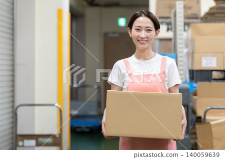 Middle-aged female worker in a warehouse Middle-aged female worker in a warehouse 140059639