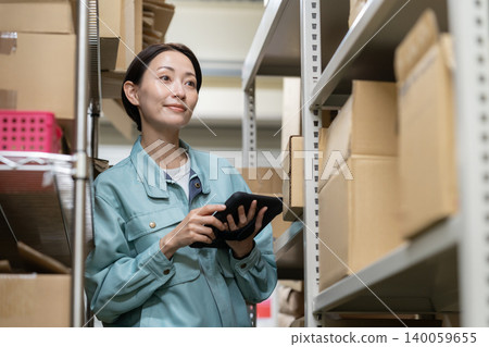Middle-aged female worker in a warehouse Middle-aged female worker in a warehouse 140059655
