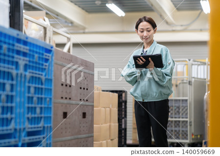 Middle-aged female worker in a warehouse Middle-aged female worker in a warehouse 140059669