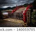 Mount Osorezan in Aomori, one of Japan's three most sacred sites: A dark photograph of the arched bridge reminiscent of a protective barrier and the heavy, overcast clouds. 140059705