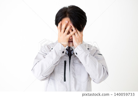 一位身穿灰色工作服的中年商人,用手摀著臉,神情沮喪,背景是白色。 一位身穿灰色工作服的中年商人,用手摀著臉,神情沮喪,背景是白色。 140059733