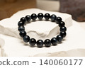 Natural stone blue tiger eye bracelet rests on white rock surface 140060177