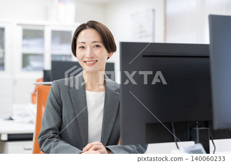 A middle-aged businesswoman working in an office A middle-aged businesswoman working in an office 140060233
