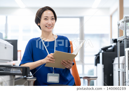 A middle-aged businesswoman working in an office A middle-aged businesswoman working in an office 140060289