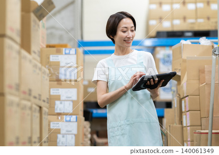 Middle-aged woman working in a warehouse Middle-aged woman working in a warehouse 140061349