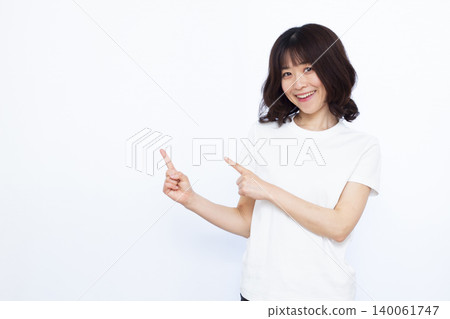 A woman who raises her index finger with a smile 140061747