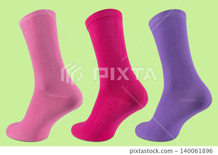 Set of three colorful women's socks on ghost mannequin in pink, magenta and purple colors on light green background Set of three colorful women's socks on ghost mannequin in pink, magenta and purple colors on light green background 140061896