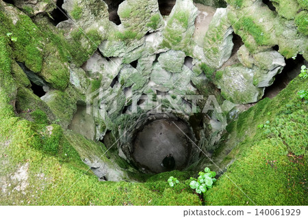 High angle view looking down the mossy stone Initiation Well of Quinta da Regaleira in Sintra, Portugal High angle view looking down the mossy stone Initiation Well of Quinta da Regaleira in Sintra, Portugal 140061929