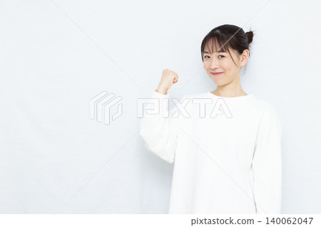 A woman doing a guts pose with a smile A woman doing a guts pose with a smile 140062047