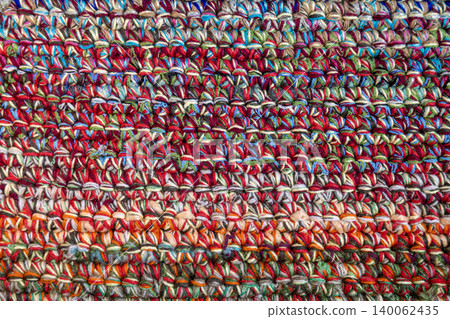 Multicolored knitted textile fabric pattern with vibrant woven yarn detail Multicolored knitted textile fabric pattern with vibrant woven yarn detail 140062435