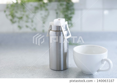 A tumbler with a heat retention function that holds a coffee drip pack; the image is of brewing piping hot coffee. A tumbler with a heat retention function that holds a coffee drip pack; the image is of brewing piping hot coffee. 140063187