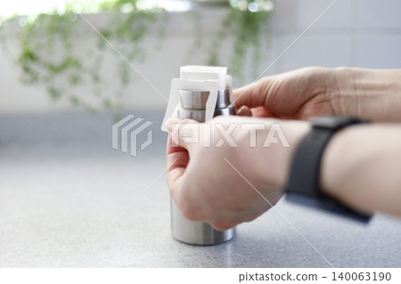 A hand setting a coffee drip pack into a tumbler with heat retention function; an image of brewing piping hot coffee. A hand setting a coffee drip pack into a tumbler with heat retention function; an image of brewing piping hot coffee. 140063190