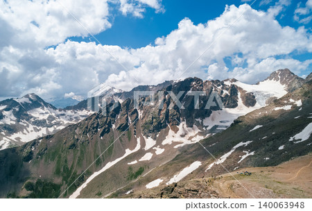 Majestic mountain range with snow and a glacier under a blue sky Majestic mountain range with snow and a glacier under a blue sky 140063948