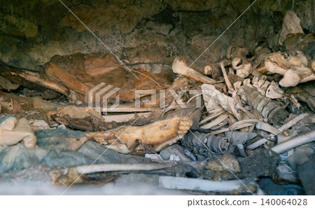 Interior view of an ancient Dargavs burial crypt, revealing human skeletal remains and deteriorated textiles Interior view of an ancient Dargavs burial crypt, revealing human skeletal remains and deteriorated textiles 140064028