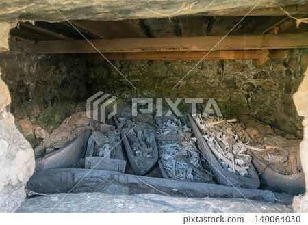 Ancient burial crypt in Dargavs City of the Dead holds many human remains in wooden boat-shaped coffins Ancient burial crypt in Dargavs City of the Dead holds many human remains in wooden boat-shaped coffins 140064030