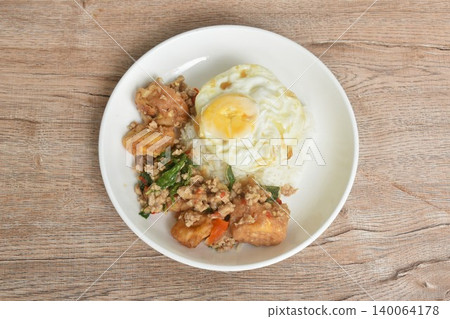 spicy chili fried chop pork and tofu couple basil topping rice dressing egg on plate spicy chili fried chop pork and tofu couple basil topping rice dressing egg on plate 140064178