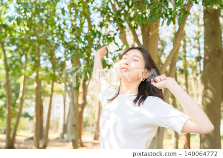 Japanese woman stretching in a park Japanese woman stretching in a park 140064772