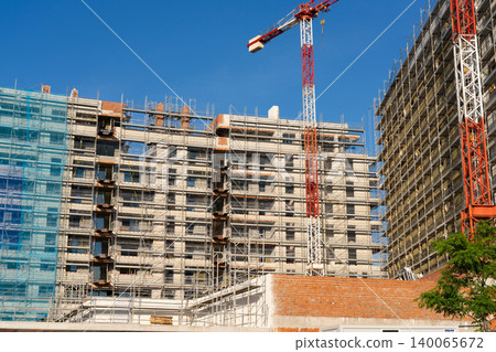Large residential construction site with tower cranes and scaffolding Large residential construction site with tower cranes and scaffolding 140065672