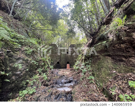 An old concrete erosion control dam and stream stand deep in the forest. 140065959