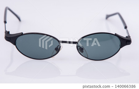 Vintage black slim metal frame sunglasses. Classic retro dark mini lens eyewear on white background 140066386