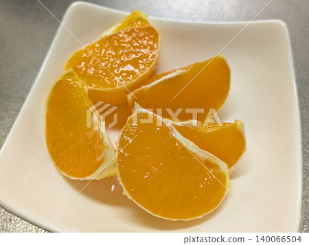 Fresh and juicy sliced mandarins served on a white plate. 140066504
