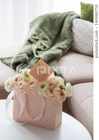 Ranunculus Bouquet with Gift Bag and Envelope in Cozy Living Room Ranunculus Bouquet with Gift Bag and Envelope in Cozy Living Room 140066758