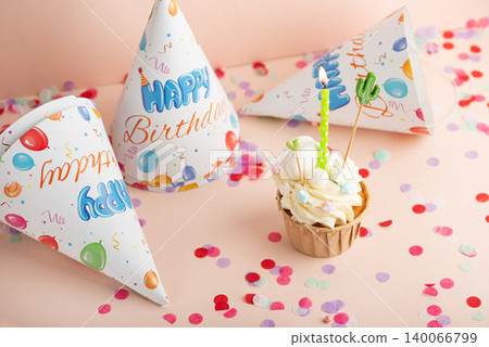 Cupcake with burning candle celebrating a birthday party Cupcake with burning candle celebrating a birthday party 140066799