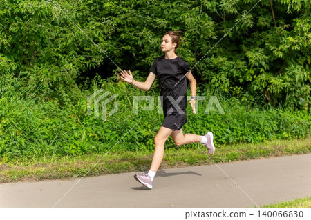 Young woman jogging on a park path Young woman jogging on a park path 140066830
