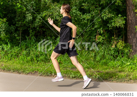 Young woman running on a park path Young woman running on a park path 140066831