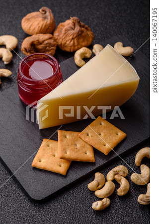 Aged cheese in a triangular block with jam, figs, and nuts. Aged cheese Aged cheese in a triangular block with jam, figs, and nuts. Aged cheese 140067195