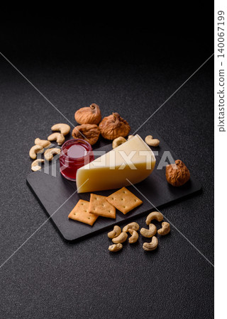 Aged cheese in a triangular block with jam, figs, and nuts. Aged cheese Aged cheese in a triangular block with jam, figs, and nuts. Aged cheese 140067199