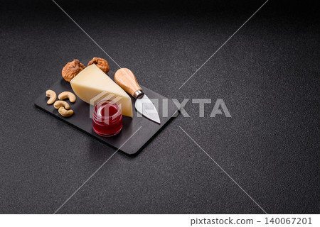 Aged cheese in a triangular block with jam, figs, and nuts. Aged cheese Aged cheese in a triangular block with jam, figs, and nuts. Aged cheese 140067201