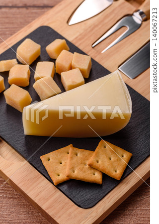 Aged cheese in a triangular block with jam, figs, and nuts. Aged cheese Aged cheese in a triangular block with jam, figs, and nuts. Aged cheese 140067213