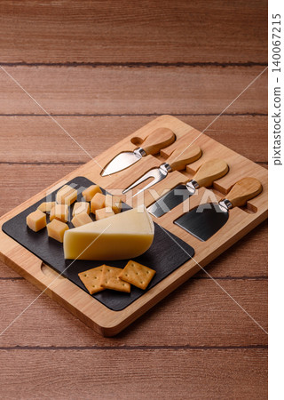 Aged cheese in a triangular block with jam, figs, and nuts. Aged cheese Aged cheese in a triangular block with jam, figs, and nuts. Aged cheese 140067215