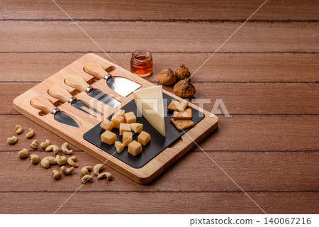 Aged cheese in a triangular block with jam, figs, and nuts. Aged cheese Aged cheese in a triangular block with jam, figs, and nuts. Aged cheese 140067216