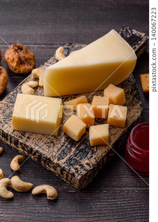 Aged cheese in a triangular block with jam, figs, and nuts. Aged cheese Aged cheese in a triangular block with jam, figs, and nuts. Aged cheese 140067223