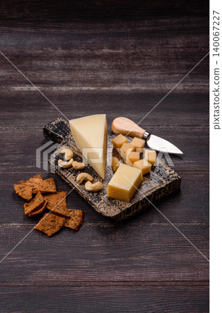 Aged cheese in a triangular block with jam, figs, and nuts. Aged cheese Aged cheese in a triangular block with jam, figs, and nuts. Aged cheese 140067227