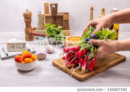 Woman preparing fresh radishes for cooking salad Woman preparing fresh radishes for cooking salad 140067388